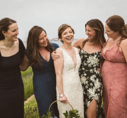 a bride friends laughing outdoors seaside