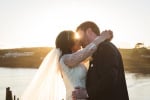 A bride and groom kiss at sun set overlooking the sea at Inchydoney Lodge and Spa