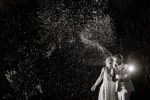 A bride and groom spray champagne at night after their wedding at Inchydoney Lodge and Spa